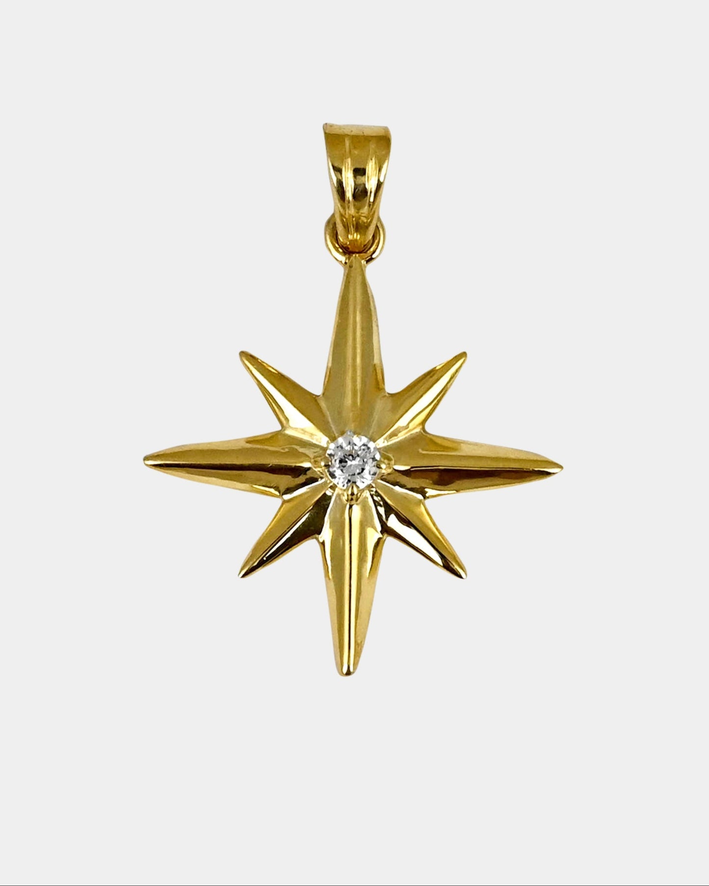 Gold star-shaped pendant with a diamond on a white background
