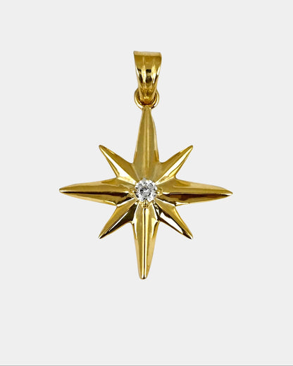 Gold star-shaped pendant with a diamond on a white background