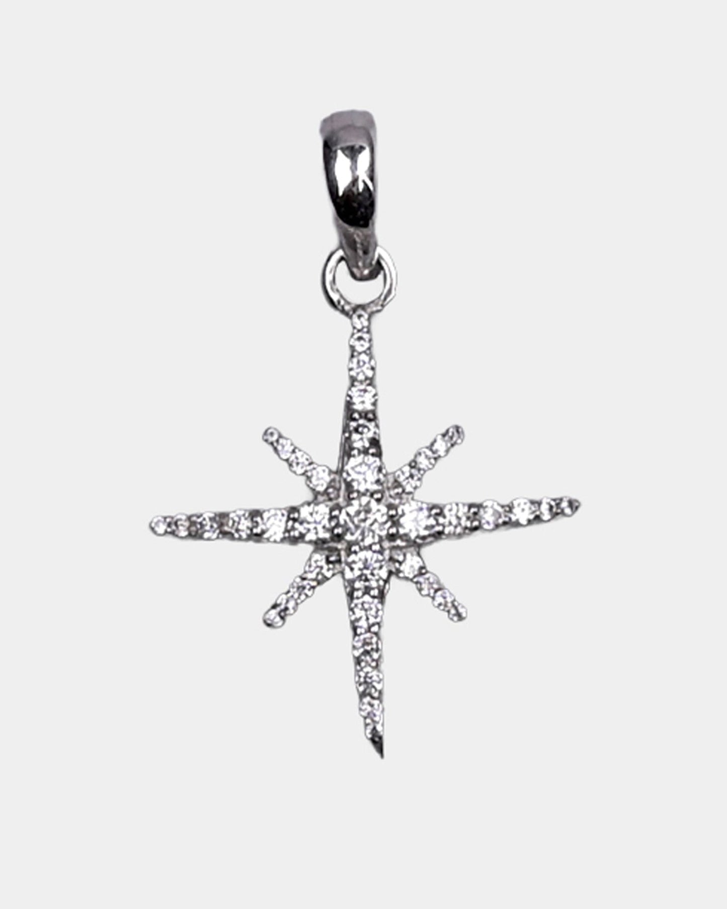 Star-shaped silver pendant with clear stones on a light gray background