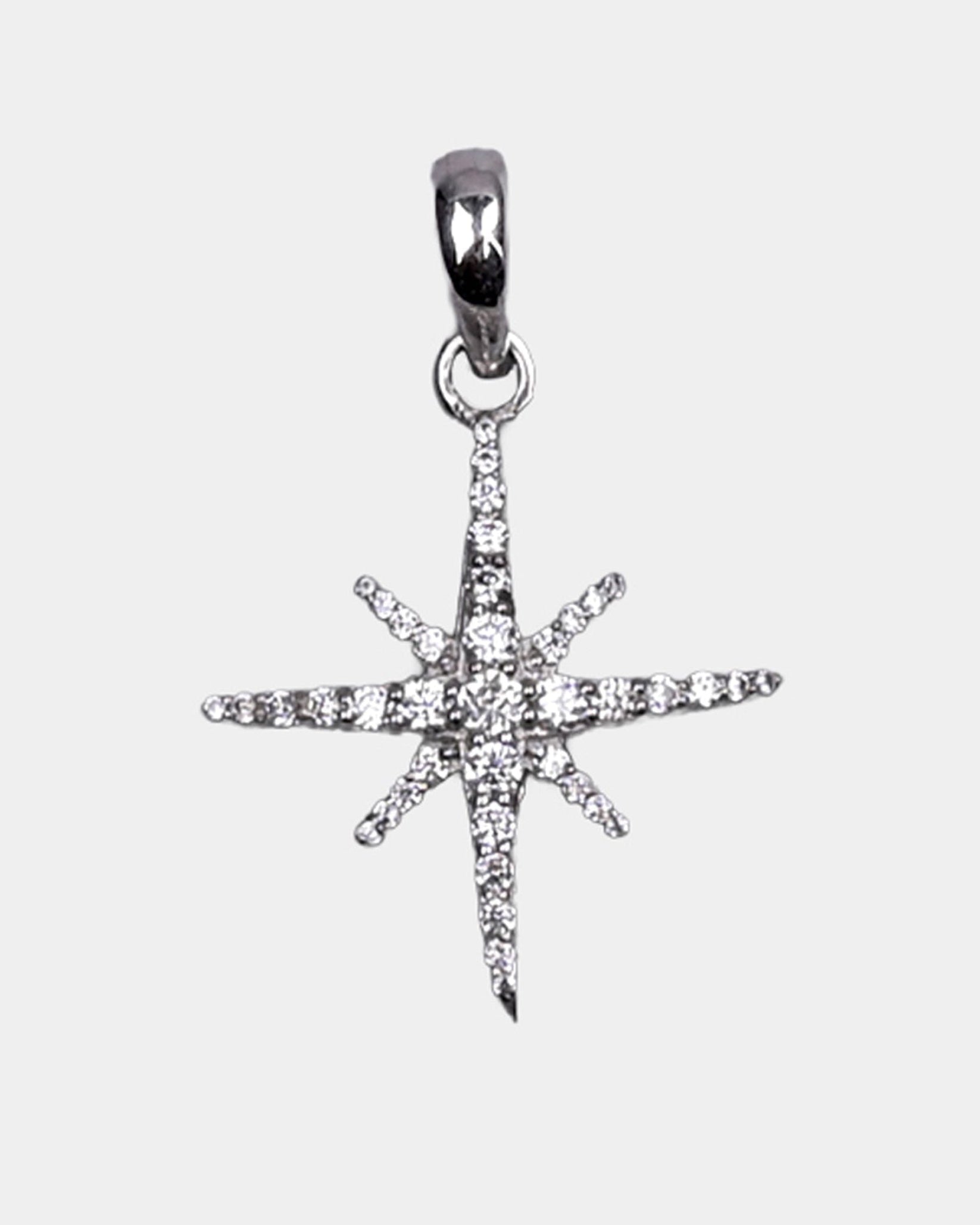 Star-shaped silver pendant with clear stones on a light gray background